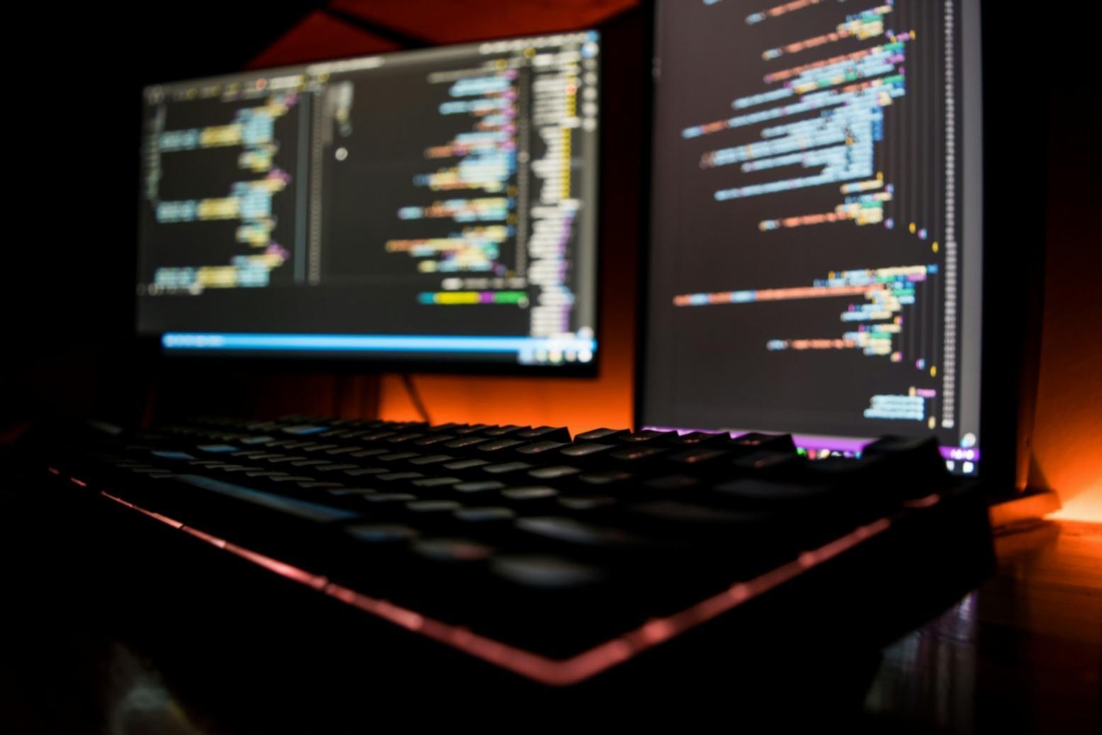 Modern blockchain development workspace showing multiple monitors with smart contract code and testing environments